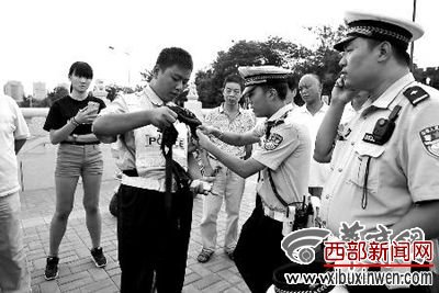 昨日,邵译琦(右一)和同事将假协管员的警帽、臂章等警用装备去掉 华商报记者 袁琛 摄